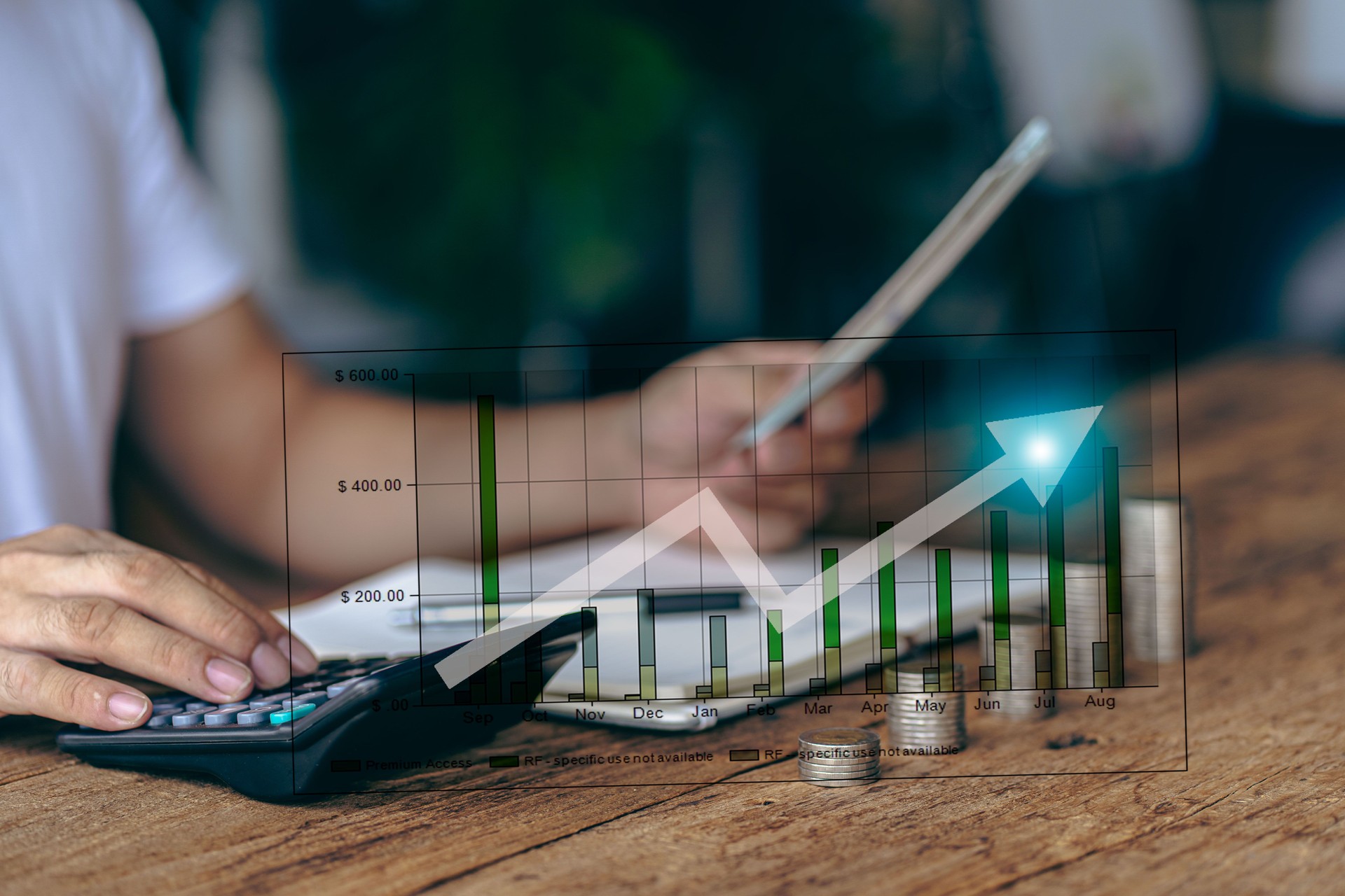 Asian man calculating finances about future expenses or investments at home While the coins are arranged like a graph ahead of the concept of Savings and accounts